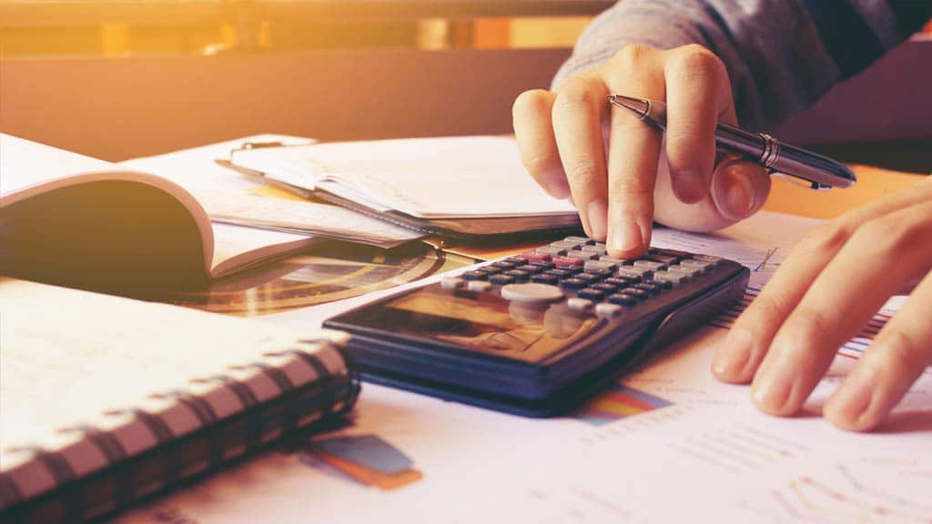 Businessman using a calculator while budgeting